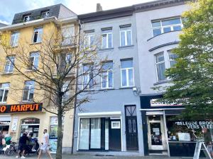 een gebouw op een straat waar mensen op de stoep lopen bij Sint-Jans Appartments in Antwerpen