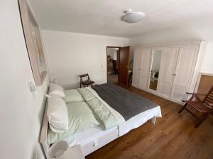 Schlafzimmer mit einem weißen Bett und Holzboden in der Unterkunft Haus Sonnenweg 6 auf der Sonnenseite im Westerwald in Höhr-Grenzhausen