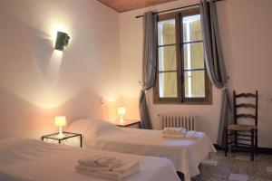 a bedroom with two beds and a window and two lamps at Hameau Montplaisir in Béziers