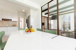 a white kitchen with a table with a bowl of fruit at Villa Sea Breeze Jarea in Playa Blanca