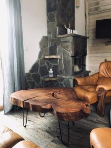 a living room with a log coffee table in front of a fireplace at Carlina House in Szczawnica