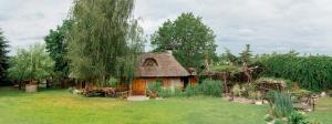 a small house with a thatched roof in a yard at Hotel Jaśmin in Owińska