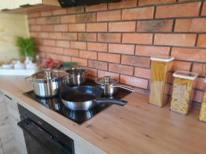 un bancone della cucina con pentole e padelle su un piano cottura di Willa Kaszubiak a Ostrzyce