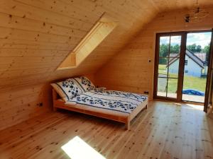 a bedroom in a log cabin with a bed and a window at Willa Kaszubiak in Ostrzyce