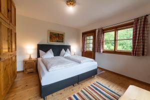 a bedroom with a bed and two windows at Ferienhaus Murmi in Kirchdorf in Tirol