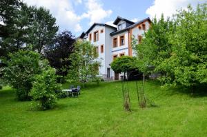 a house with a table and chairs in a yard at Apartmány Irisis in Chvaleč