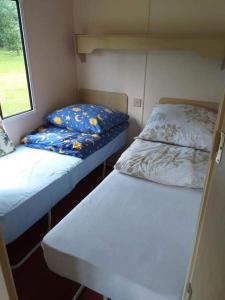 a small room with two beds and a window at Na Piaskach Domek na Roztoczu in Narol
