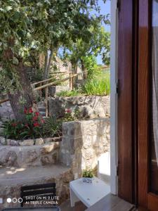 an open door to a garden with a stone wall at Acquamarina Accommodation in Massa Lubrense