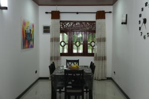 comedor con mesa, sillas y ventana en Nima villa, en Tangalle