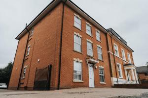 un gran edificio de ladrillo rojo con puerta blanca en The Stay Company, Dalby House en Derby