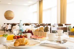 a table with breakfast food on it in a restaurant at ACHAT Hotel Corbin München Airport in Freising