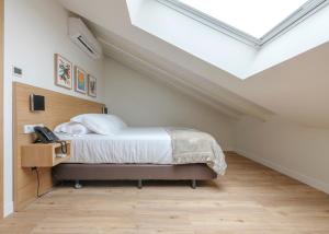 a bedroom with a bed and a skylight at El Museo Suites in Málaga