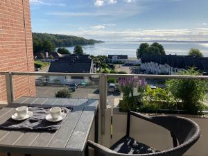 a table on a balcony with a view of the water at Pier39 Ferienwohnung Wassersleben Flensburg in Harrislee