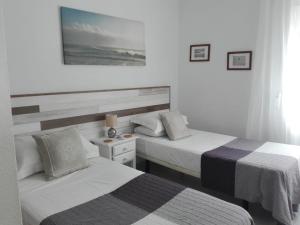 una camera d'albergo con due letti e una foto a parete di Apartment Las Tres Piedras a Conil de la Frontera