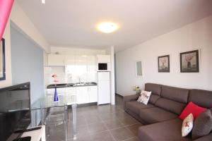 een woonkamer met een bank en een keuken bij Apartment Acapulco Sunset View in Playa Fañabe