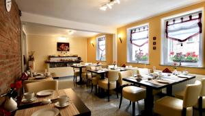 a dining room with tables and chairs and windows at Frühstückspension "Metilstein" in Eisenach