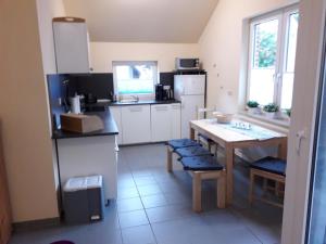 eine Küche mit einem Tisch und einer Arbeitsplatte in der Unterkunft Ferienhaus Pusteblume in Papenburg