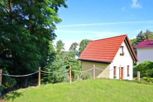 una pequeña casa blanca con techo rojo en una colina en Ferienhaus Lychen UCK 301, en Lychen
