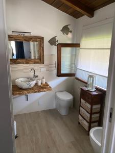 uma casa de banho com um lavatório, um WC e um espelho. em Ca LuBella em Carrara