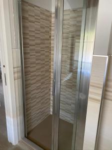 um chuveiro com uma porta de vidro num quarto em Ca LuBella em Carrara