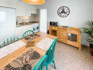a kitchen with a wooden table with chairs and a clock at Suite Natura @ Casa del Lago in Puerto de la Cruz