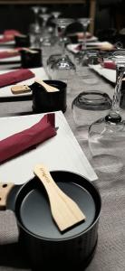 un tavolo con un piatto nero e un cucchiaio di legno di L'Entre 2 Cols a Saint-Martin-sur-le-Chambre