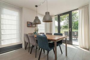 a dining room with a wooden table and chairs at Villa Klein Geluk in Egmond aan Zee