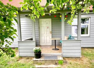 a white shed with a table in front of it at Lejnieki Apartment 2 in Pape