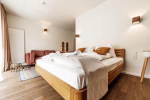 a bedroom with a large bed with white sheets at Blackhome Graz I contactless check-in in Graz