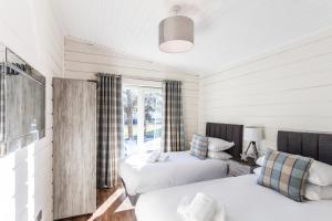 a bedroom with two beds and a window at Roydon Marina Village Lodges in Roydon
