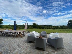 eine Terrasse mit Stühlen, einem Tisch und einem Sonnenschirm in der Unterkunft L’Etable in Trouville-sur-Mer