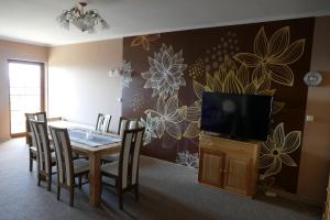 a dining room with a table and a television at Dwór Bogdałów in Koniaków