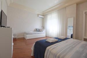 a bedroom with a bed and a couch in it at Profumo di Zagara - Locazione turistica in Agrigento