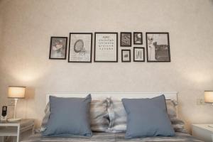 a group of framed pictures on a wall above a bed at Profumo di Zagara - Locazione turistica in Agrigento