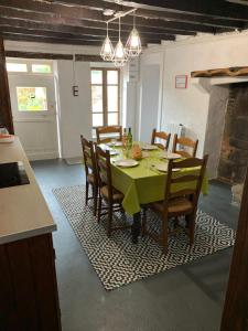 a dining room with a table with a green table cloth at Doxie Cottage in Saint-Chabrais