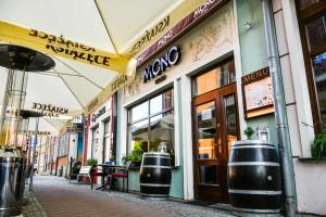 a street with a restaurant with tables and umbrellas at Stay inn Hotel Gdańsk in Gdańsk