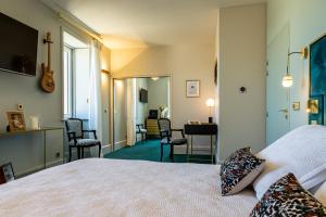 a bedroom with a bed and a desk and chairs at Olivier Leflaive Hôtel Restaurants in Puligny-Montrachet