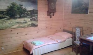 a room with a bed and a table and a clock at Apartamenty Pod Gruszką 