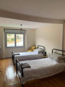 three beds in a room with a window at Doxie Cottage in Saint-Chabrais