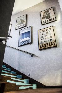 a wall with some pictures on it with stairs at Stay inn Hotel Gdańsk in Gdańsk