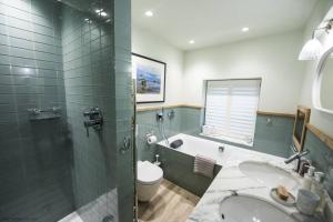 a bathroom with a tub and a toilet and a sink at The Garth 5 Star Gold Luxury Cottages in St Ives +7 photos