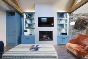 a living room with a fireplace and blue shelves at The Garth 5 Star Gold Luxury Cottages in St Ives