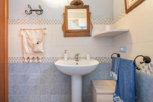 Un baño con lavabo, espejo y toallas. en Casa Vacanza de Dinu, en SantʼAnna Arresi 34 fotos más