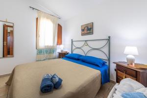 Un dormitorio con una cama con almohadas azules. en Casa Vacanza de Dinu, en SantʼAnna Arresi