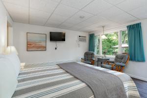 ein Schlafzimmer mit einem Bett und zwei Stühlen und einem Schreibtisch in der Unterkunft Towne Lyne Motel in Ogunquit