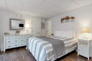 a white bedroom with a bed and a tv at Towne Lyne Motel in Ogunquit