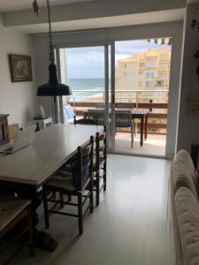 una sala da pranzo con tavolo e vista sull'oceano di Apartamento de playa Valmar - Beachfront exclusive residential a El Perellonet