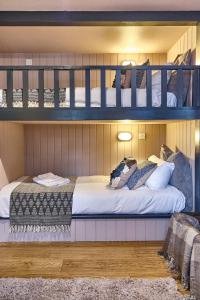 a bedroom with two bunk beds with white sheets at The Westleton Crown in Westleton