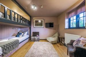 a bedroom with a bed and a couch and windows at The Westleton Crown in Westleton