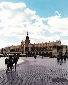 a group of people standing in front of a large building at Greg&Tom Beer House Hostel in Krakow
